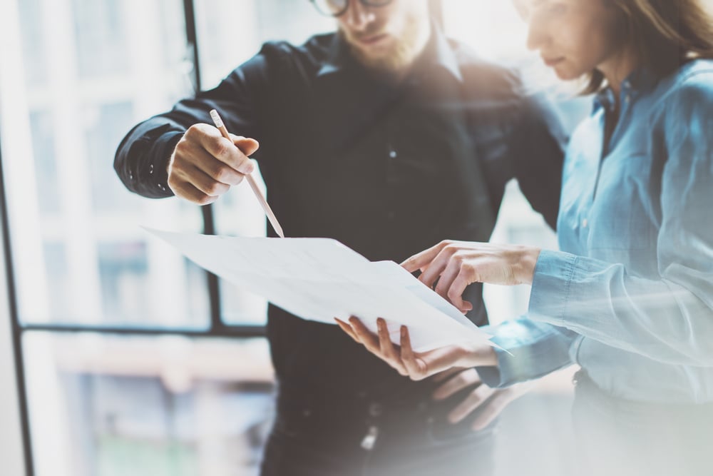 EquityZen's Shareholder playbook with man and woman reviewing paperwork
